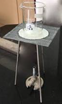 Gauze mat sitting on tripod over a Bunsen burner